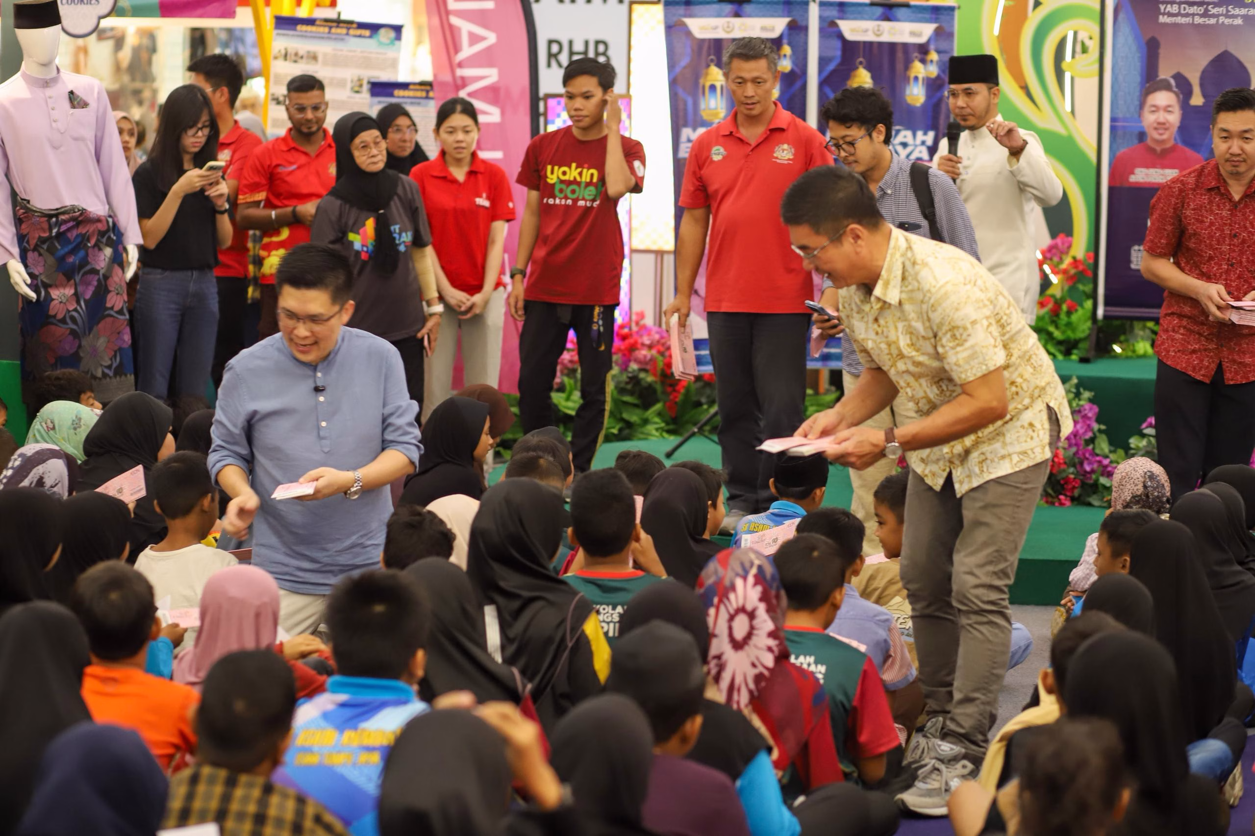 YB Wong Kah Woh, YB Teh Kok Lim (ADUN Aulong), dan YB Ong Seng Guan (ADUN Pokok Assam) sedang memberi baucar RM150 kepada murid-murid semasa Program Meriah Beraya Sejahtera Bersama 2026.